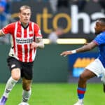 Rick Karsdorp in azione con la maglia del PSV Eindhoven, mentre disputa una partita di Eredivisie. Il terzino olandese è concentrato sul gioco, in un momento dinamico durante un'azione sul campo