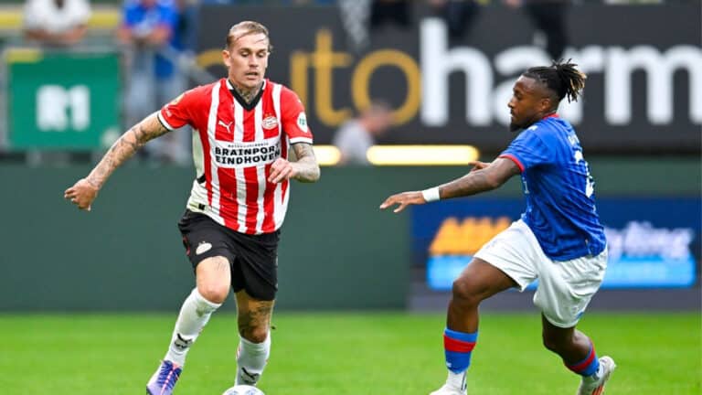 Rick Karsdorp in azione con la maglia del PSV Eindhoven, mentre disputa una partita di Eredivisie. Il terzino olandese è concentrato sul gioco, in un momento dinamico durante un'azione sul campo