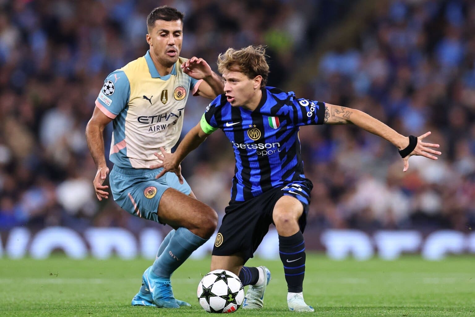 Nicolò Barella e Rodri si affrontano in un duello a centrocampo durante la partita tra Inter e Manchester City di Champions League.