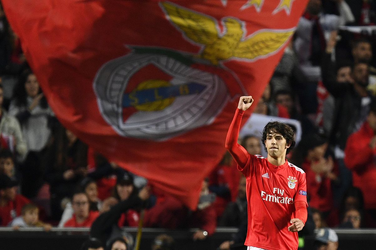João Félix con la maglia del Benfica festeggia sotto una grande bandiera del club allo stadio