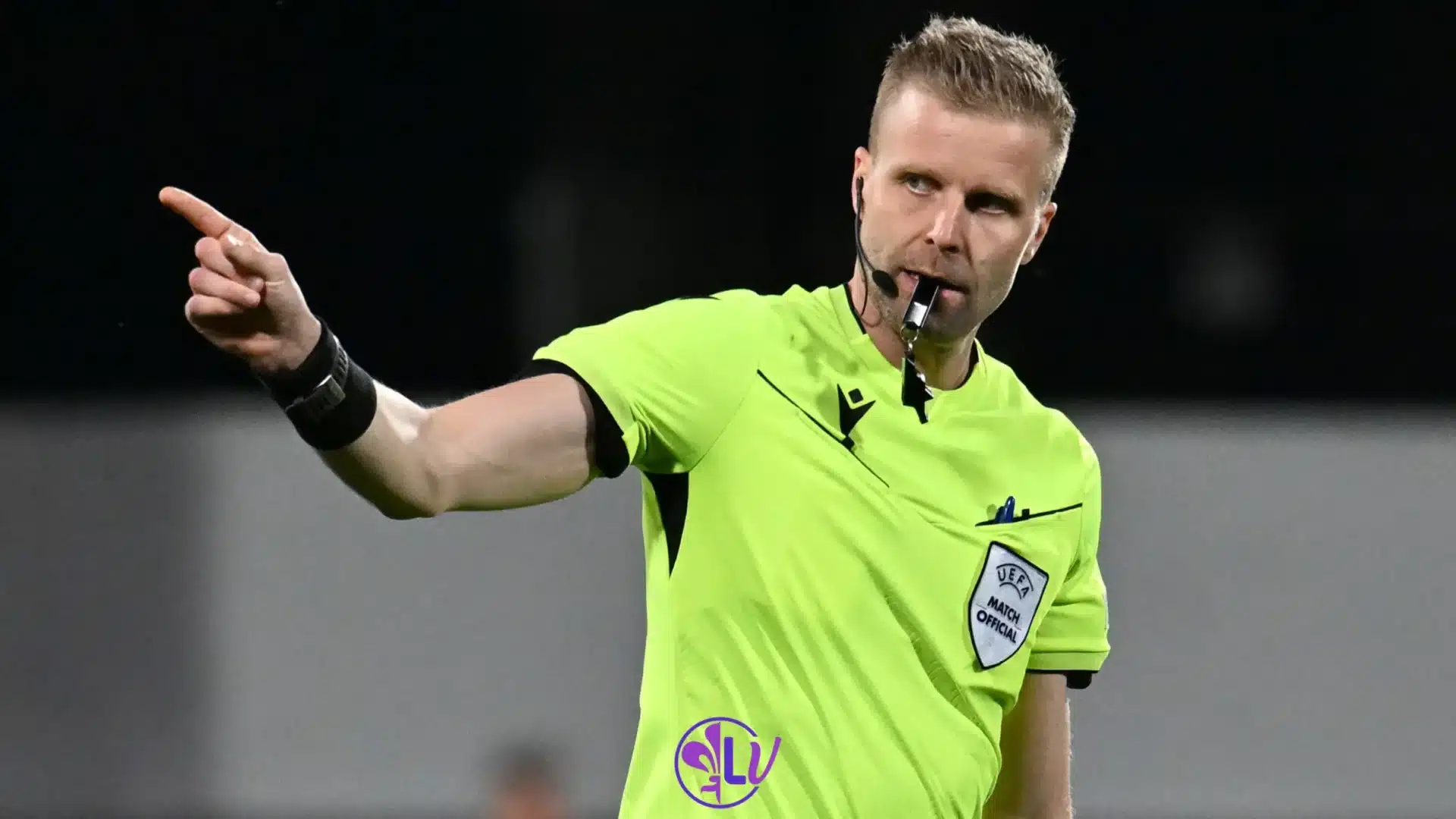 Arbitro UEFA indica una direzione durante una partita