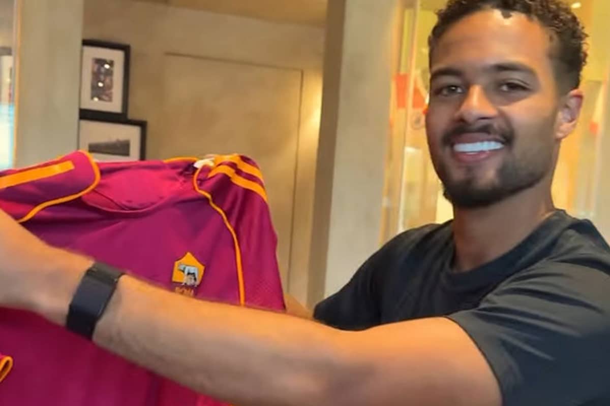 Devyne Rensch sorride con la nuova maglia home della Roma 2024/25 a Trigoria