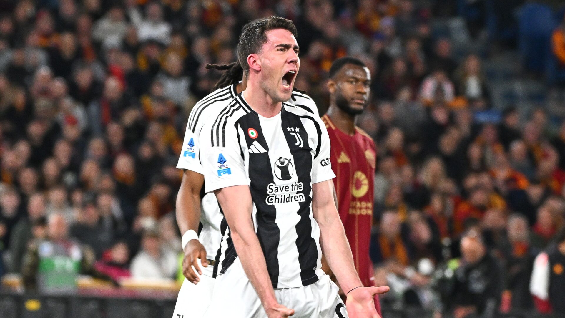 Dusan Vlahovic in maglia Juventus durante una partita contro la Roma, tra i possibili scenari di mercato